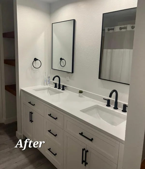 After photo of remodeled bathroom with white double vanity, black hardware, and framed mirrors